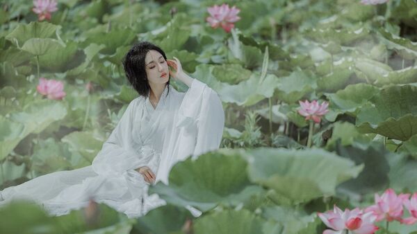 执笛荷畔听风吟：素白汉服映清池，一曲横笛惊起满塘诗